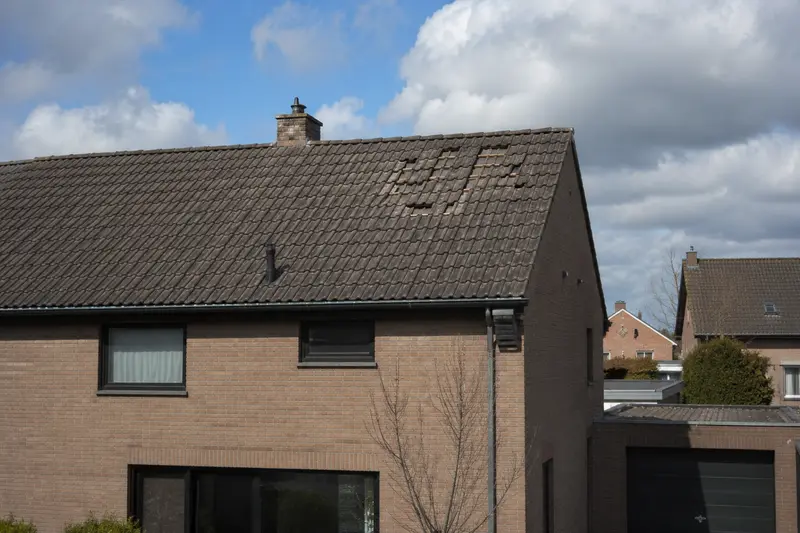 Dakwerker herstelt stormschade aan een hellend dak